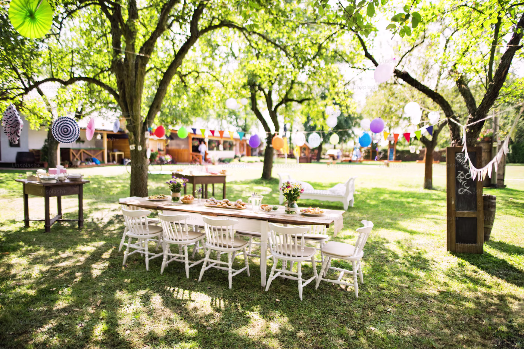 A decorated garden party table set out under trees